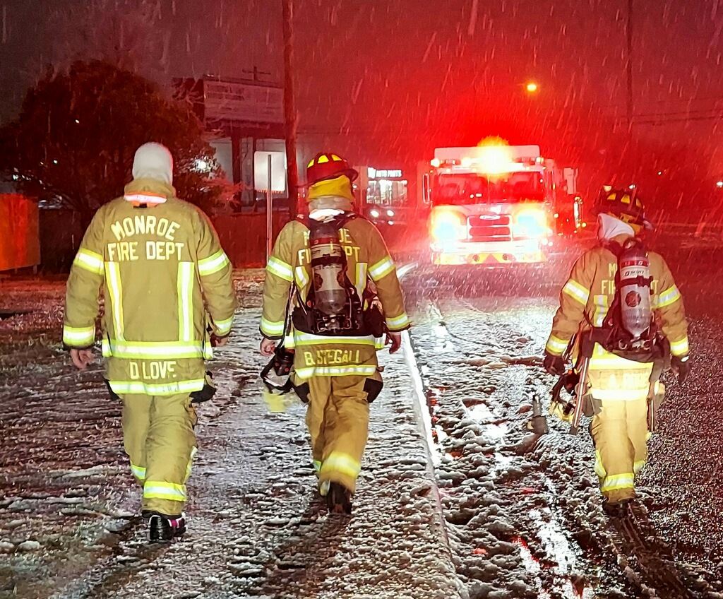Firefighters walking back to their truck in the snow at night