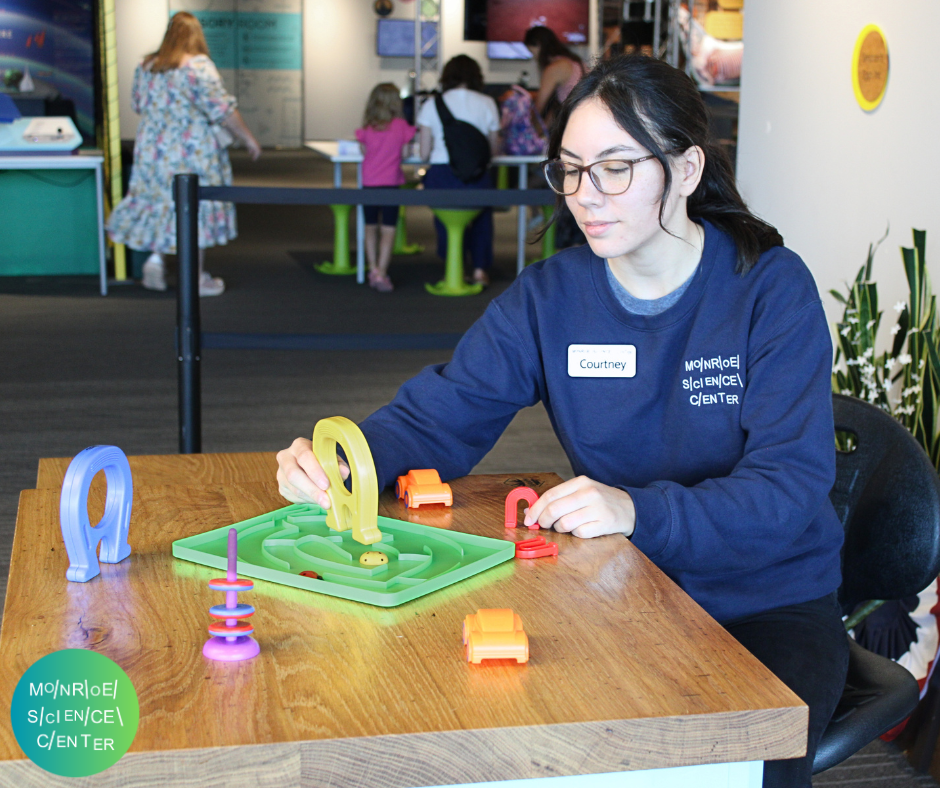 A Monroe Science Center staffer demonstrates a magnet activity.