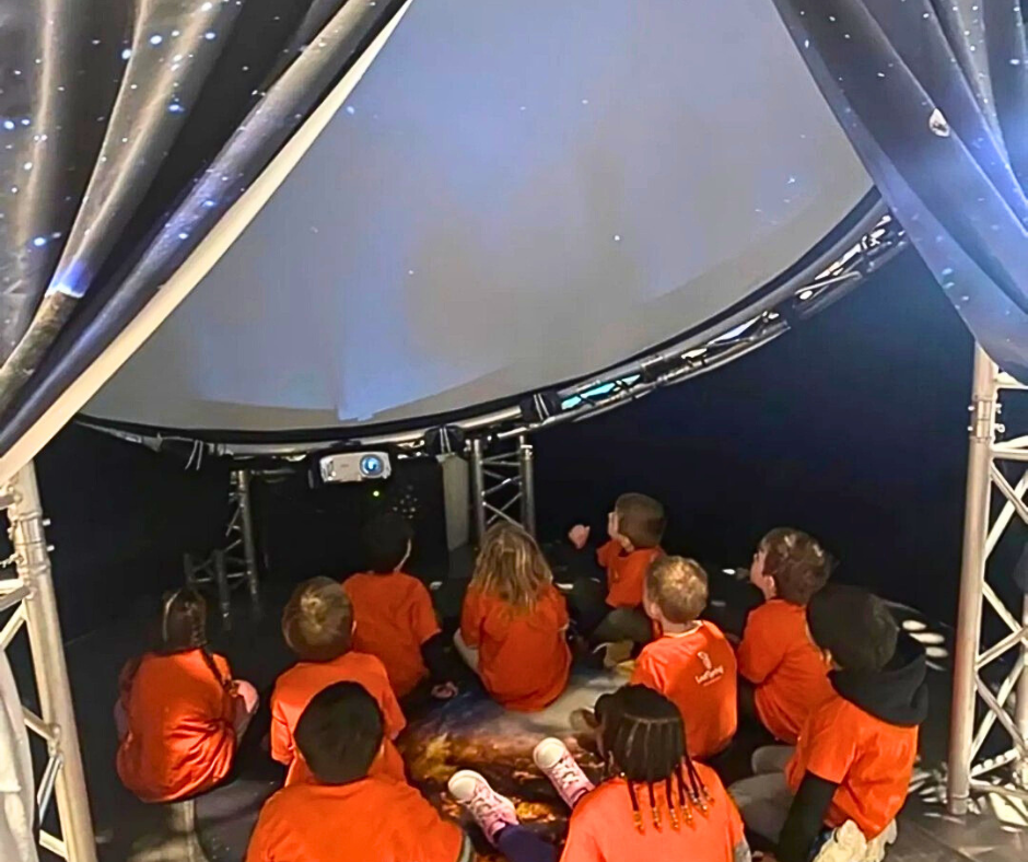 A group of children watch a 360-dome video at the Monroe Science Center.